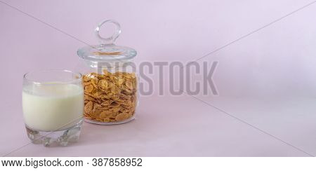 A Glass Of Milk And A Glass Jar Of Cornflakes