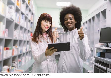 Two Confident Multiethnical Female Pharmacists In Modern Pharmacy. African American And Caucasian Wo