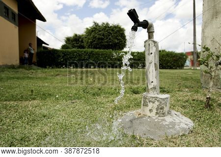 Eunapolis, Bahia / Brazil - September 16, 2009: Faucet Is Seen Spouting Water In Garden Of Residence