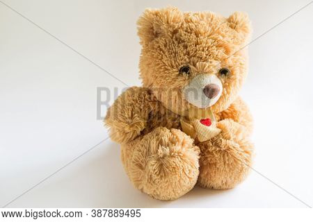 Soft Teddy Bear With Long Light Brown Fur And A Red Heart On A Scarf Around His Neck. Valentine\'s D