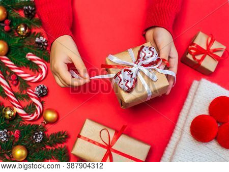 Christmas Gifts, Children's Hands Open A New Year's Gift On A Red Background, Christmas Composition 