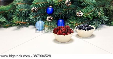 Christmas Layout. Berries On The Table, Blue Decorations On The Fir Branches. New Year
