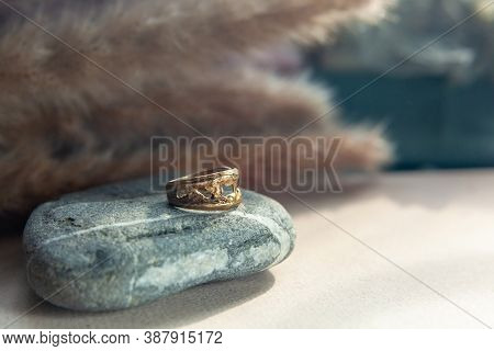 Trendy Vintage Cast Brass Ring. Jewelry Womens Ring Abstract Drawing Closeup On A Gray Natural Stone