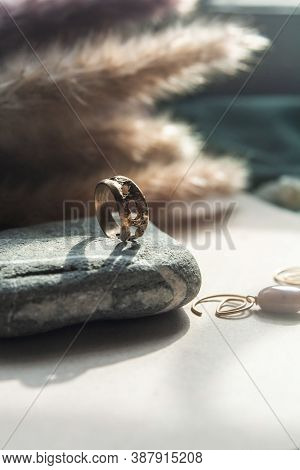 Trendy Vintage Cast Brass Ring. Jewelry Womens Ring Abstract Drawing Closeup On A Gray Natural Stone