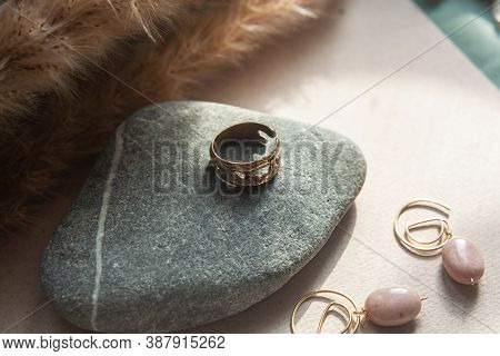 Trendy Vintage Cast Brass Ring. Jewelry Womens Ring Abstract Drawing Closeup On A Gray Natural Stone
