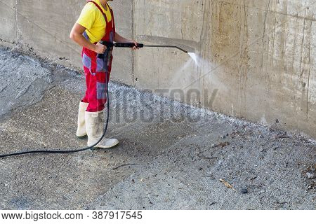 Pressure Cleaner. Worker Cleans Outdoor Dirty Concrete With High Pressure Water Jet.