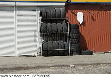 A Row Of Black New Car Tires In A Window On The Street By The Side Of The Store