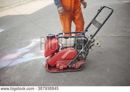 Asphalt Rammer. Laying The Road Surface. Creation Of Parking. The Worker Levels The Road Surface. Ho