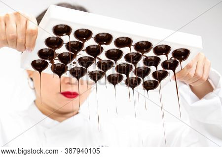 Closeup Dark Chocolate Dripping Down From Confectionery Mold. Female Chocolatier Make Hand-crafted C