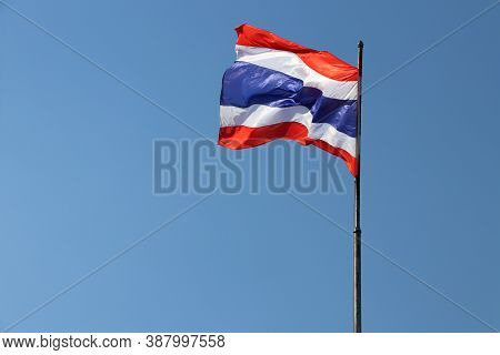 National Flag Of Thailand On Bright Blue Sky Background. Blown Away By Wind. Thailand Is One Of The 