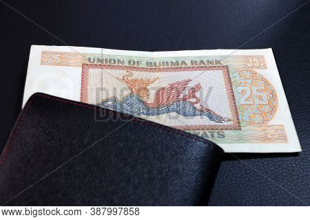 Twenty-five Of Banknote Currency Myanmar Kyats With Black Wallet On The Black Floor. It Is The Retro