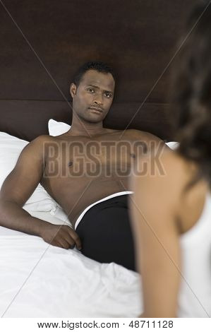 Przystojny mężczyzna African American patrząc na przycięte kobieta w łóżku