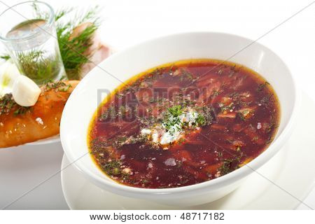 Rote Beete und Kohlsuppe mit Fleisch. Garniert mit Schinken, Schmalz, Zwiebel, Knoblauch und Wodka