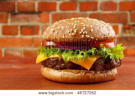 Hamburger, červená cihlová zeď na pozadí