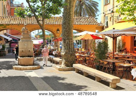 MENTON - 13 juni: Plaza med barer og restauranter i skyggen af træer og små statue i centr