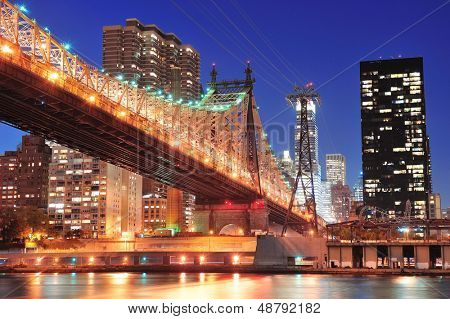 Ponte di Queensboro sopra New York City East River al tramonto con riflessioni di fiume e midtown buffet