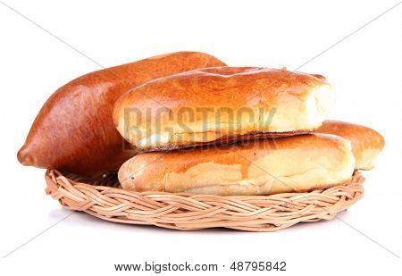 Empanadillas al horno frescos en bandeja de mimbre, aislado en blanco