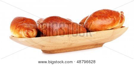 Empanadillas al horno frescas en un recipiente de madera, aislados en blanco