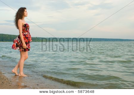 Menina perto da água na costa do mar