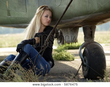 Giovane donna seduta vicino aeroplano
