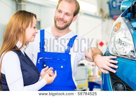 Female customer and mechanic in workshop or MOT with car for service inspection
