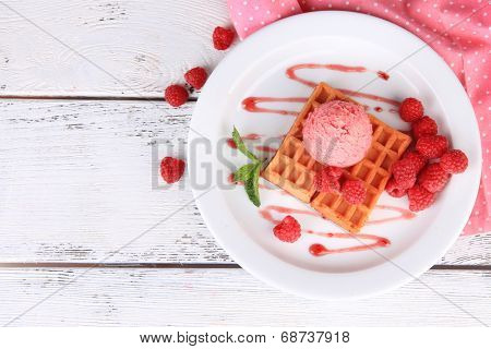 Tasty belgian waffles with ice cream on wooden table