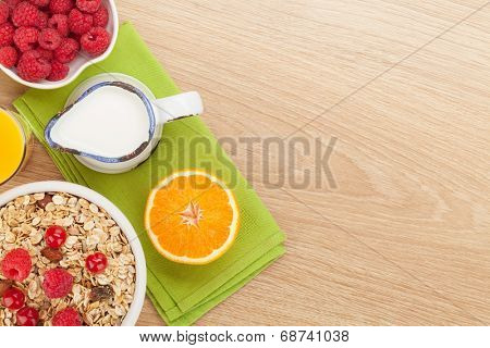 Healty breakfast with muesli, berries and orange juice. View from above on wooden table with copy space