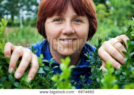 Vrouw gluren via groene bladeren