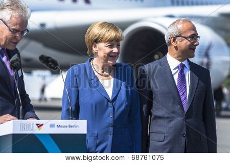 BERLIN, GERMANY - MAY 20, 2014: German Chancellor Angela Merkel (C) and Turkish Minister of transport Lutfi Elvan (R) open up the International aviation and space exhibition ILA.