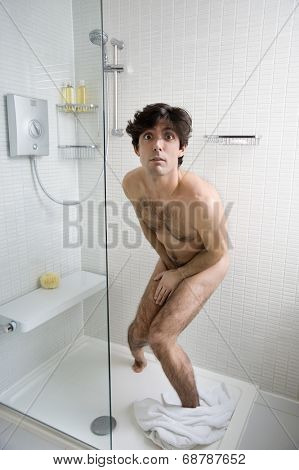 Scared naked man in bathroom