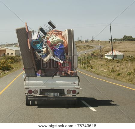Truck driving down highway with a very dangerous load that was not safely tied down.