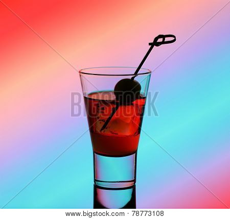 Short Drink Glass With Red Liquid And Green Olive