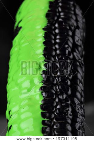 Black Corn With Pouring Green Paint Background, Macro Closeup.texture.selective Focus