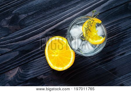 Cut lemon near the alcoholic cocktail on dark wood table top view. Blank space for text placement
