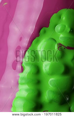 Black corn with pouring green and purple paint background, macro closeup.Texture.Abstract