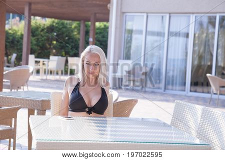 Blonde Girl Sitting At The Beach Restaurant
