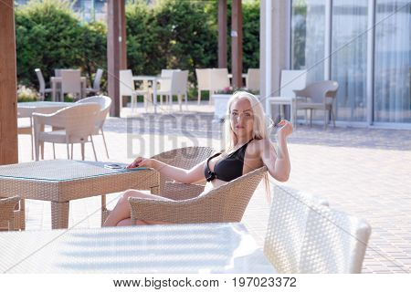 blonde girl sitting at the beach restaurant