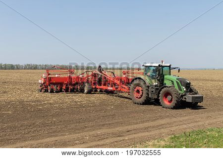 Dykanka UKRAINE - APRIL 30 2017: Farmer tractor working the field. Agricultural machines prepare a field for sowing