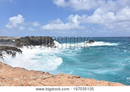 Bluffs with water splashing against them near Andicuri Beach in Aruba.