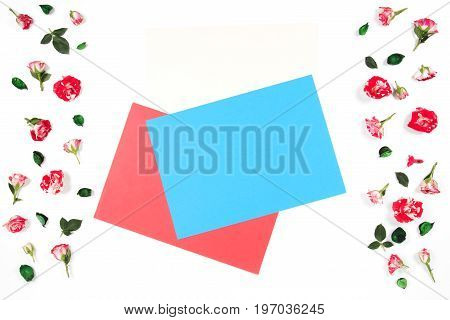 Flowers composition. Frame made of rose flowers and empty blank colored paper sheets for text in the middle.