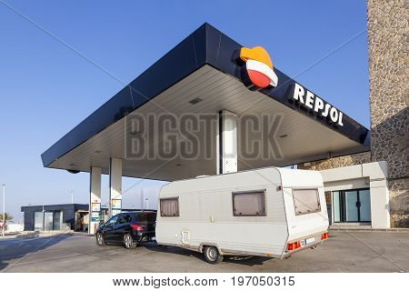 Murcia Spain - June 6 2017: Car with a caravan trailer at the Repsol self service gas station in southern Spain