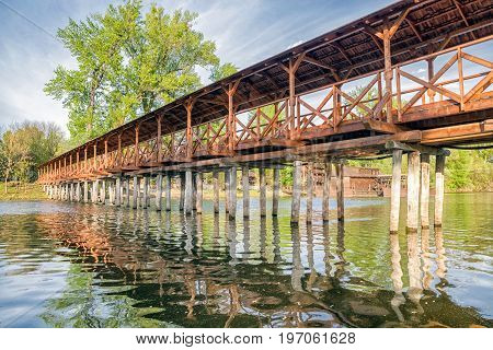 Historical wooden pedestrian bridge over river Danube and watermill in Kolarovo Slovakia