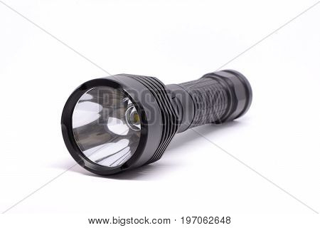 Isolated black metal flashlight on white background