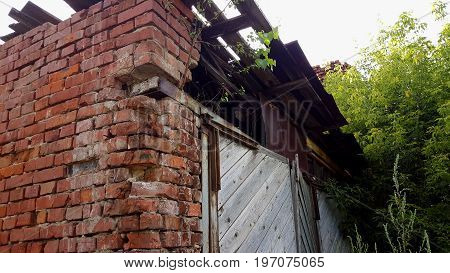 Old crumbling brick house, abandoned building background. Brick wall