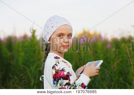 Little Girl With Digital Tablet On The Nature