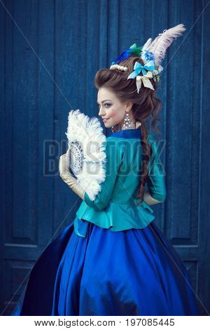 Beautiful caucasian girl dressed in the style of the Renaissance. Photo in blue tones