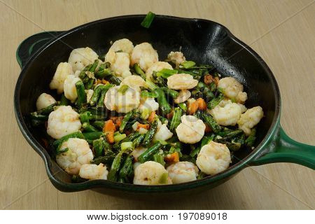 Making shrimp and vegetable stir fry in cast iron frying pan skillet