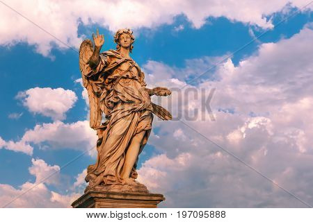 Marble statue of Angel with the Nails at sunset, one of the ten angels on Saint Angel Bridge, symbols of Christ's Passion, Rome, Italy