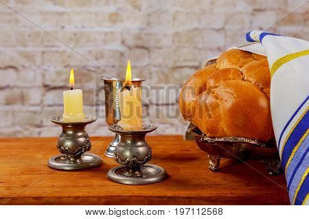 Shabbat Candles In Glass Candlesticks With Blurred Covered Challah