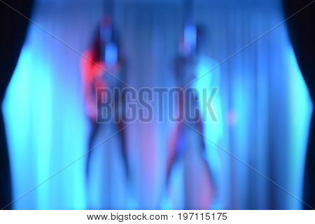 Two sexy strippers blur effect without focus - can be used as blurred background